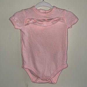 Delicate pink colored onesie with ruffles.